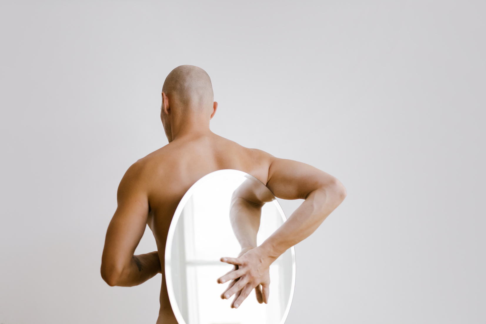 Topless Man Sitting on White Chair